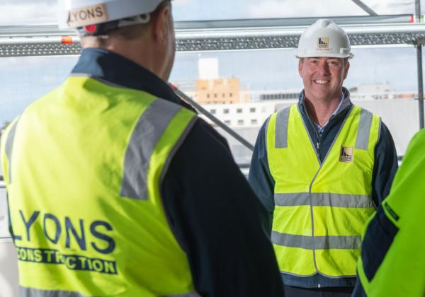 Lyons Construction Team Members standing in a building under construction