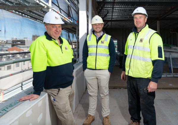 Three Lyons Construction Team Members standing in a building under construction